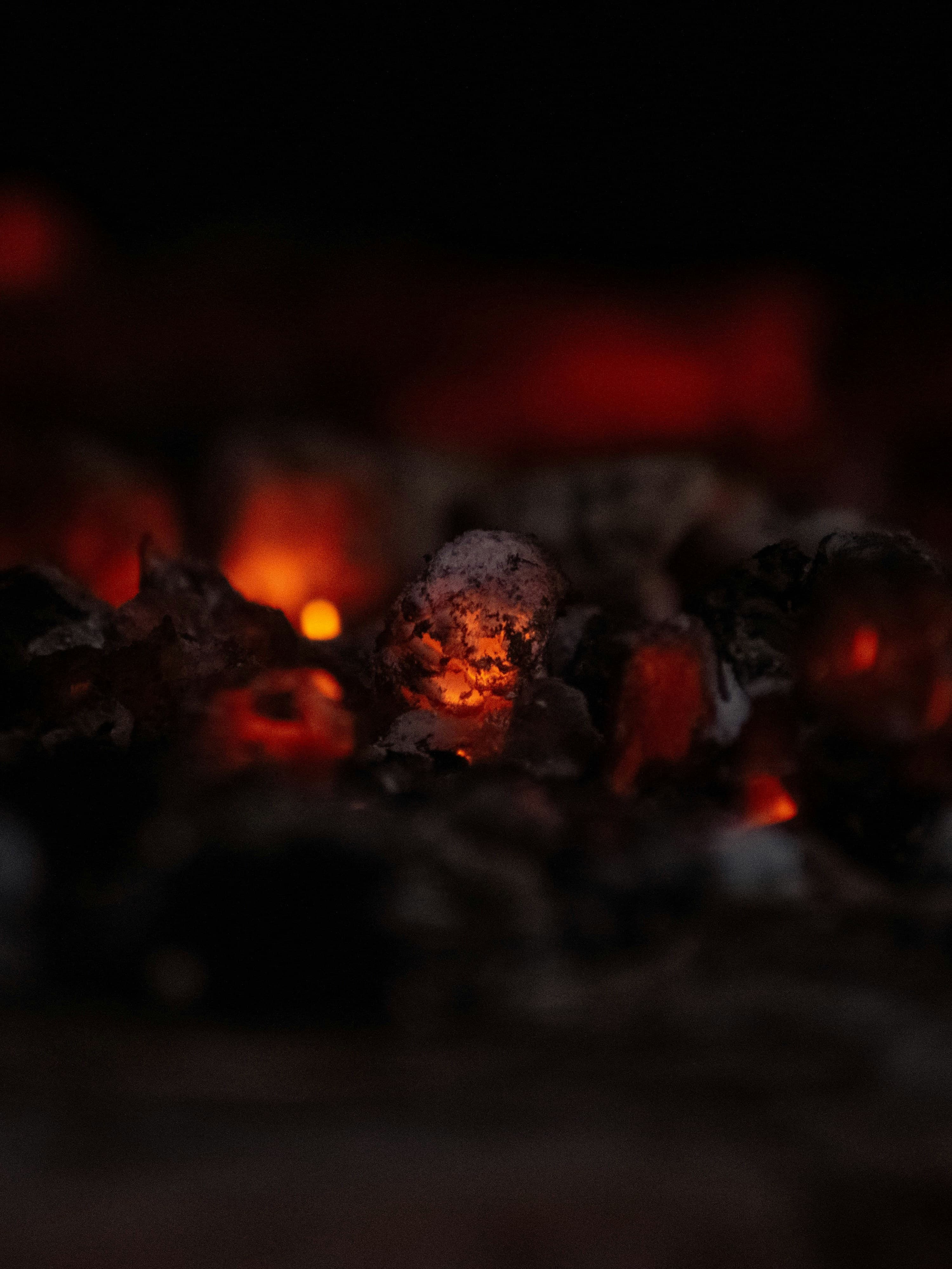 Single glowing coconut charcoal ember, dark surround